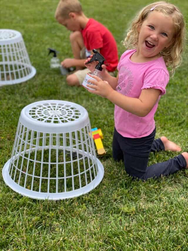 laughing girl with a spray bottle doing lego water play