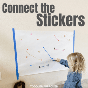 girl drawing lines on a paper from one sticker to another