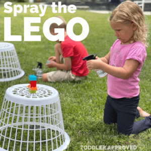 girl spraying the LEGO brick tower with a spray bottle